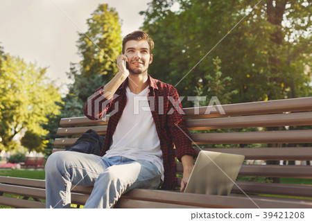 Handsome man talking on phone and smiling outdoors 39421208