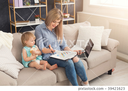 Young mother working and spending time with baby 39421623