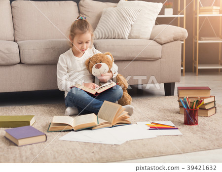 Happy little female child hugging her teddy bear Happy little female child hugging her teddy bear 39421632