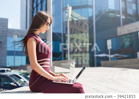 Businesswoman working with laptop outdoors 39421855