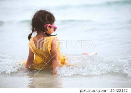 Cute asian child girl sit and play on beach 39422152