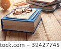 Books and glasses on a wooden table desk 39427745