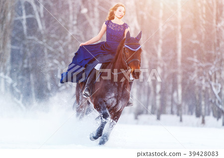 Young girl in dress riding horse on winter field Young girl in dress riding horse on winter field 39428083