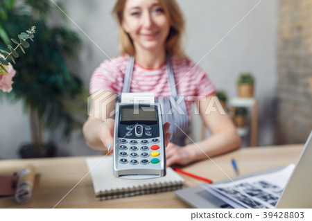 Woman is offering payment terminal for paying with Woman is offering payment terminal for paying with 39428803