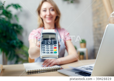Woman is offering payment terminal for paying with 39428819