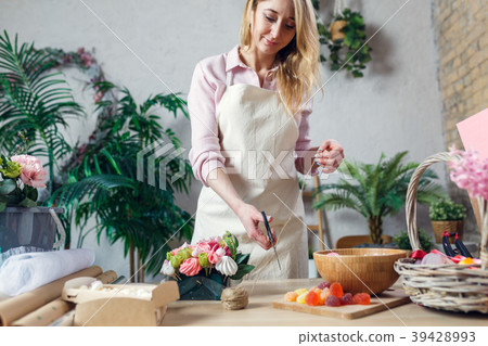 Image of florist woman with scissor-cutting rope 39428993