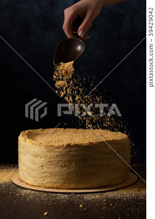 Woman decorating traditional napoleon cake Woman decorating traditional napoleon cake 39429042