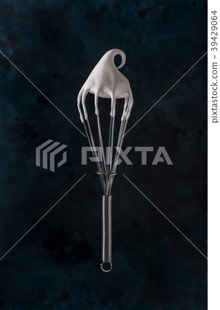 Whisk with meringue cream over dark blue bg 39429064