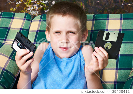 Little boy with floppy disk and audio cassette 39430411