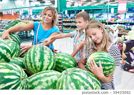 Mom with kids choose watermelon at grocery store Mom with kids choose watermelon at grocery store 39433092