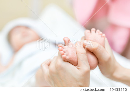 Mother making feet massage for infant baby. Parent Mother making feet massage for infant baby. Parent 39435350