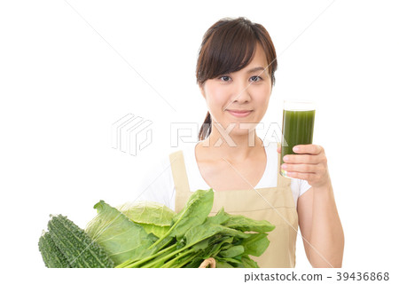 A woman holding a glass with vegetable juice A woman holding a glass with vegetable juice 39436868