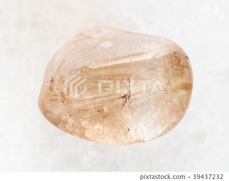 tumbled Rutilated Quartz gemstone on white marble tumbled Rutilated Quartz gemstone on white marble 39437232