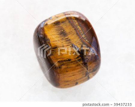 polished tiger-eye gem stone on white marble polished tiger-eye gem stone on white marble 39437233