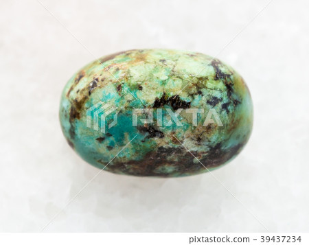 tumbled turquoise gemstone on white marble 39437234