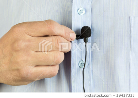 A small buttonhole microphone on a man's shirt. 39437335