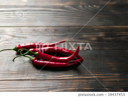 Hot chili peppers on a dark wooden background. 39437453