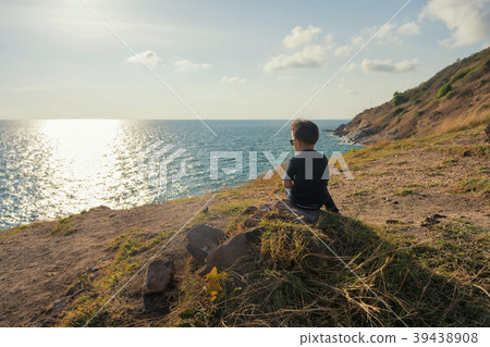 Young boy at cliff look seacape at sunset Young boy at cliff look seacape at sunset 39438908