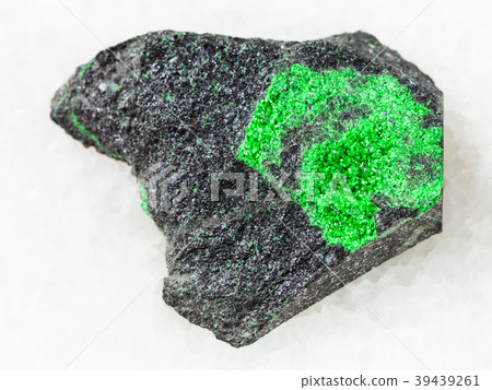 Uvarovite crystals on raw rock on white marble Uvarovite crystals on raw rock on white marble 39439261