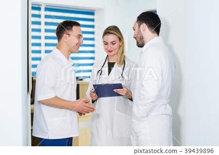 Group of doctors discussing and working together Group of doctors discussing and working together 39439896