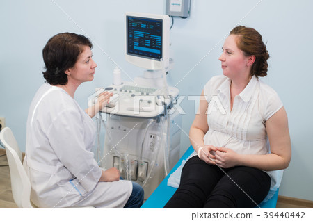 Gynecologist showing ultrasound photo to pregnant Gynecologist showing ultrasound photo to pregnant 39440442