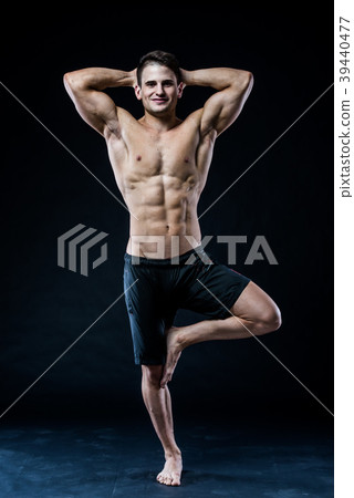 Young strong athlete is making yoga on black 39440477