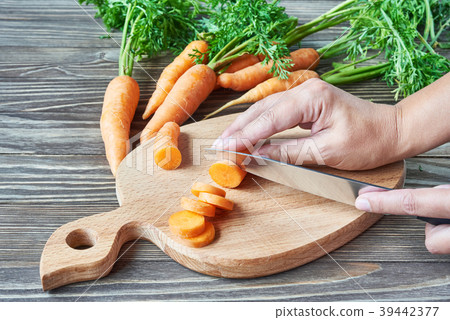 Woman cutting carrots Woman cutting carrots 39442377