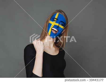 Young woman with Sweden flag painted on her face Young woman with Sweden flag painted on her face 39443177