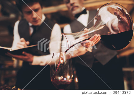 Close up. Two experienced sommeliers taste wine. 39443573