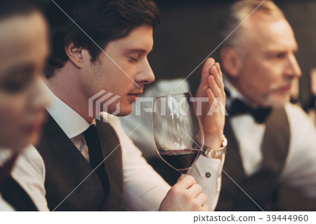 Young handsome sommelier man tasting red wine Young handsome sommelier man tasting red wine 39444960