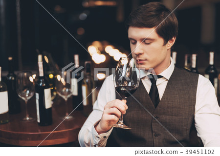 Confident handsome sommelier tasting wine Confident handsome sommelier tasting wine 39451102