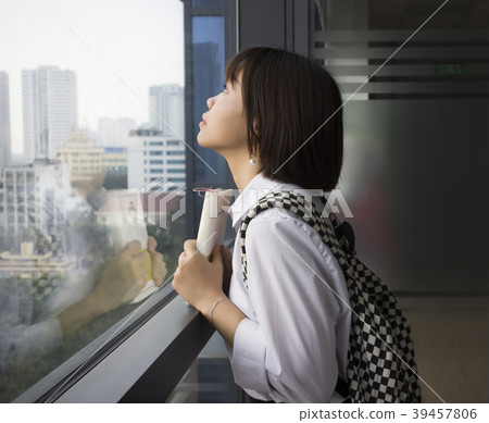 girl looking out next to window girl looking out next to window 39457806