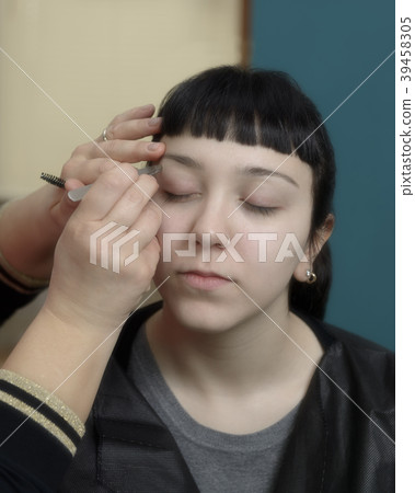 Young woman having eyebrow correction Young woman having eyebrow correction 39458305
