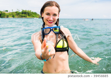 Woman with snorkelling equipment standing in ocean 39458885