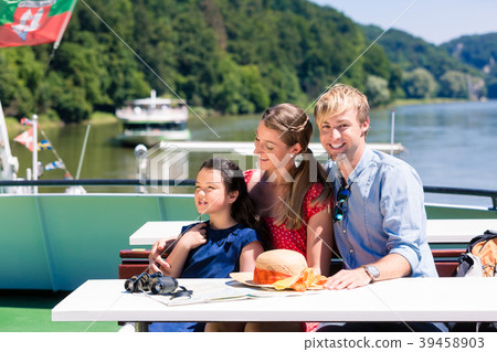 Family on river cruise looking at mountains from 39458903