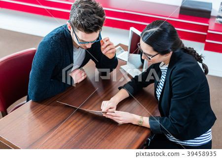 Customer and sales woman in optician store Customer and sales woman in optician store 39458935
