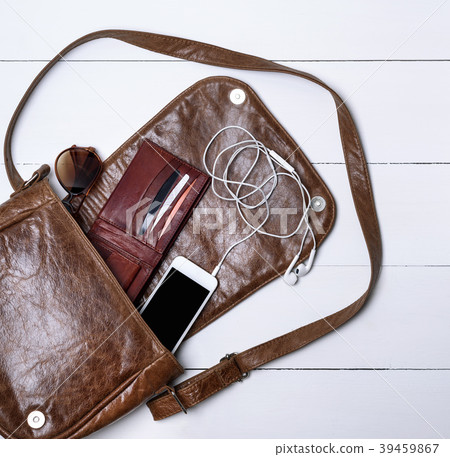 open female brown leather bag, a white smartphone open female brown leather bag, a white smartphone 39459867
