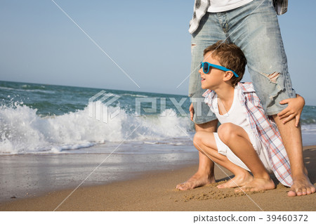 Father and son playing on the beach at the day time. 39460372