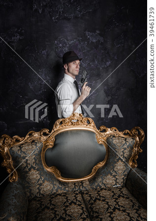 Handsome detective in hat holding a gun in the Handsome detective in hat holding a gun in the 39461739