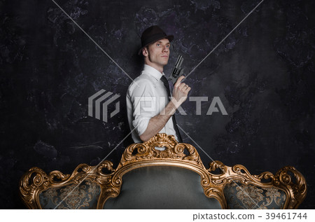 Handsome detective in hat holding a gun in the Handsome detective in hat holding a gun in the 39461744