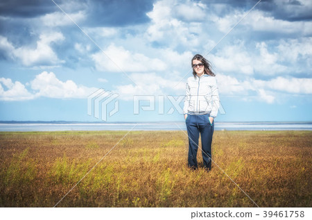 Young woman smiling in the midst of a orange lawn Young woman smiling in the midst of a orange lawn 39461758