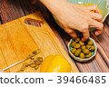 Woman cutting green olives for cooking 39466485