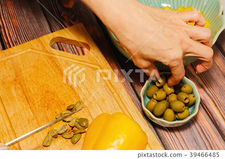 Woman cutting green olives for cooking Woman cutting green olives for cooking 39466485