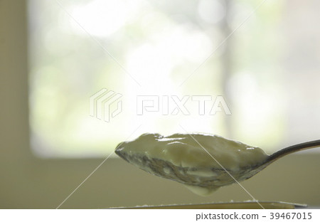 yogurt scooping on spoon from plastic cup yogurt scooping on spoon from plastic cup 39467015