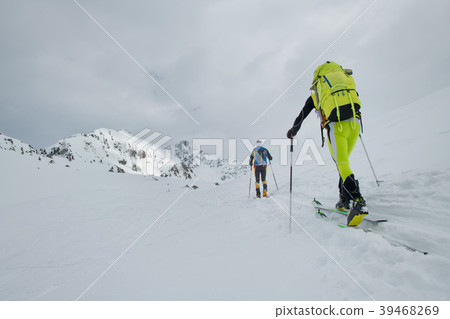 Ski mountainers in the shadows of the mountains. 39468269