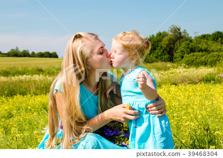 caucasian mother kissing daughter outdoors caucasian mother kissing daughter outdoors 39468304