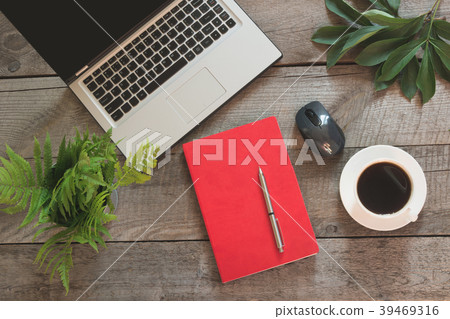Open laptop with red notebook on table. Top view. 39469316
