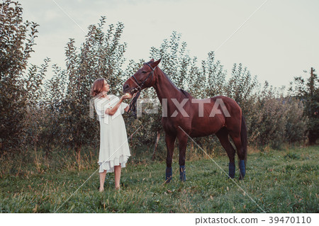 A woman feeds a horse A woman feeds a horse 39470110