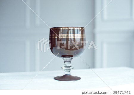 A vintage brown crystal wine glass on wooden table A vintage brown crystal wine glass on wooden table 39471741