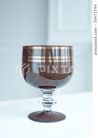 A vintage brown crystal wine glass on wooden table A vintage brown crystal wine glass on wooden table 39471744